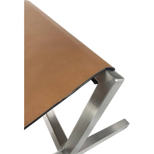 A modern dining bench made of leather in a coastal director style, in cognac and brushed stainless steel.
